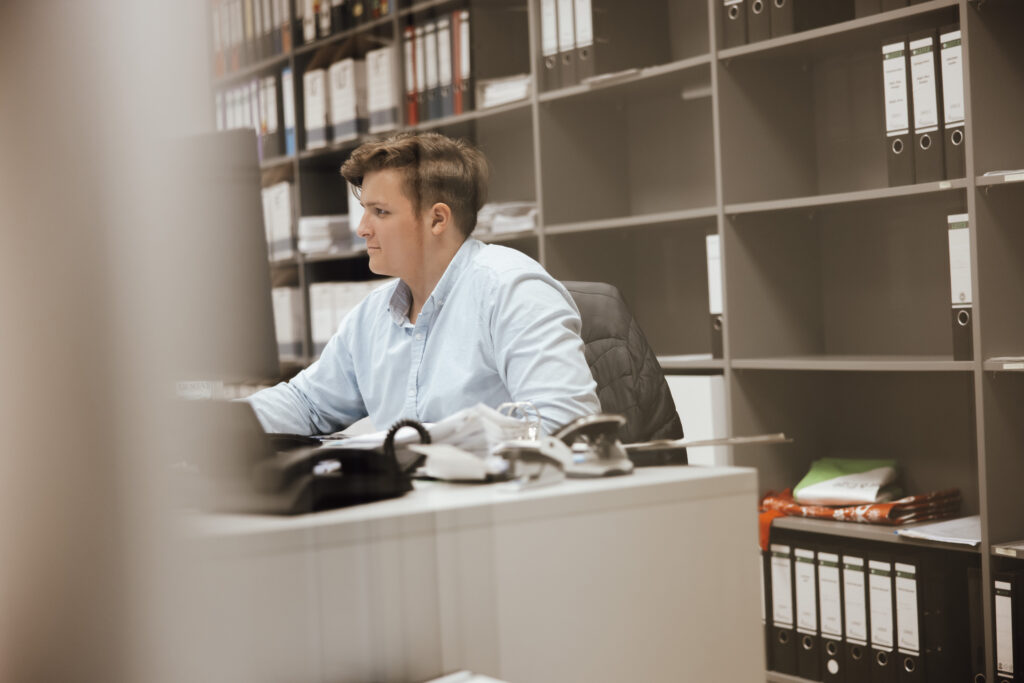 Mann sitzt am Schreibtisch im Büro
